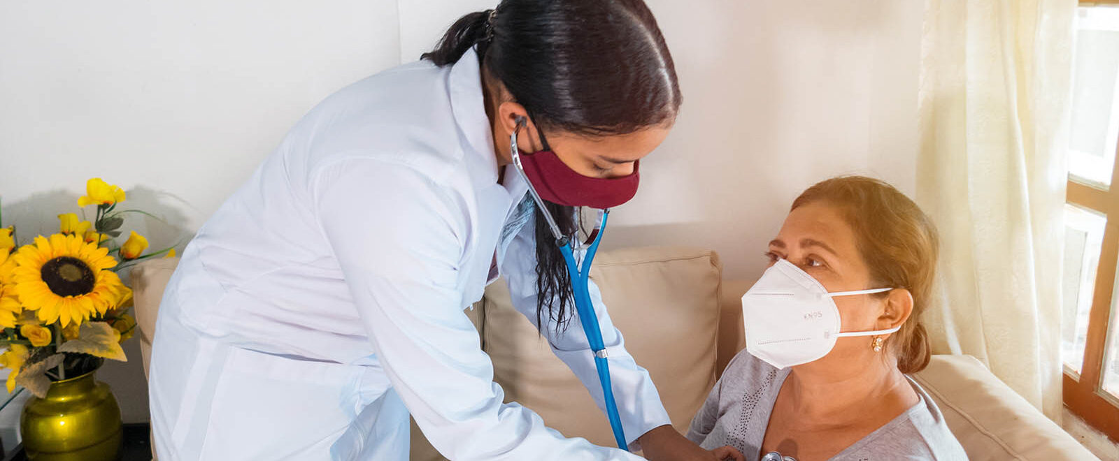 Home care professional checking elderly woman's vitals