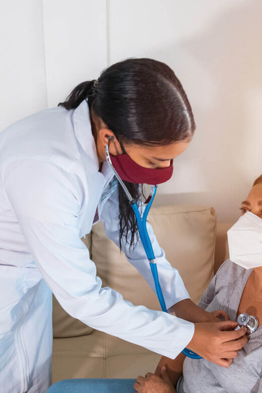 Home care professional checking elderly woman's vitals